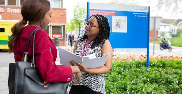 Volunteer chatting to patient outside hospital