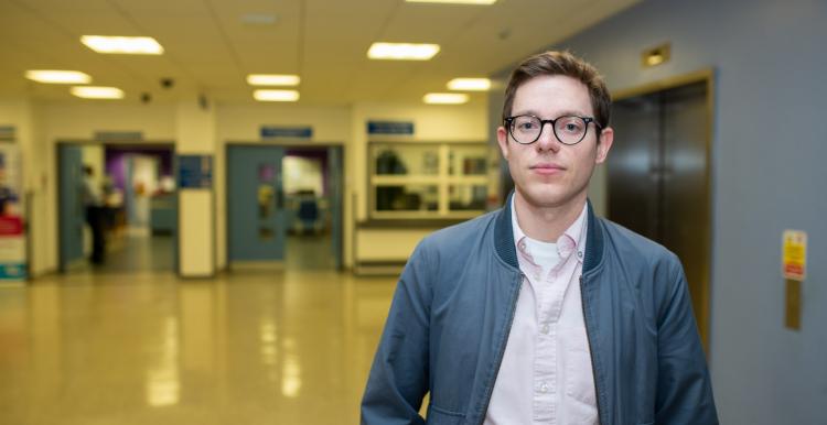 Young man standing face on to camera in a hospital hallway