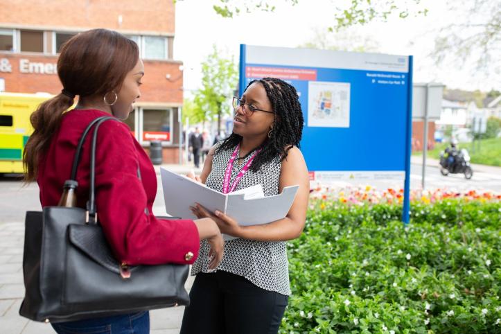 Volunteer chatting to patient outside hospital