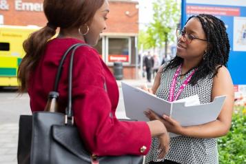 Healthwatch volunteer talking to patient outside hospital